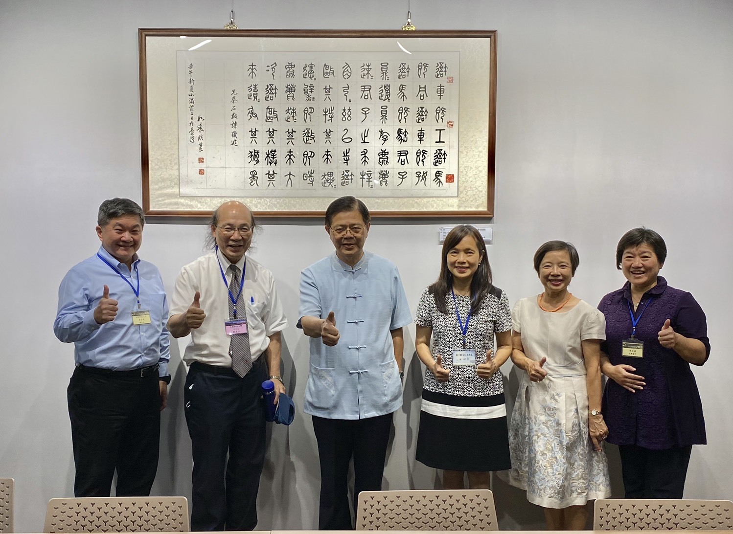 張校長(右二)與貴賓合照的背面是先秦石鼓詩書法; 主題 : 獵遊 ; 作者 : 孫如晨臨摹 ; 篆書體，由陳西京前董事長珍藏